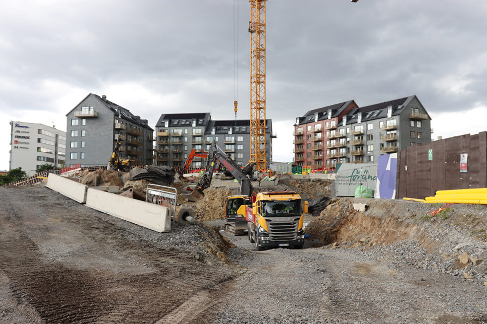 arbetsmaskiner i förgrunden och bakom syns en byggkran och det första kvarteret i trästaden stockholm wood city